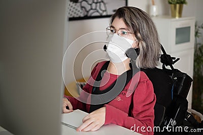Disabled woman with muscular dystrophy working in front of a computer Stock Photo