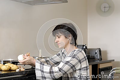 Disabled woman in wheelchair cooking dinner Stock Photo