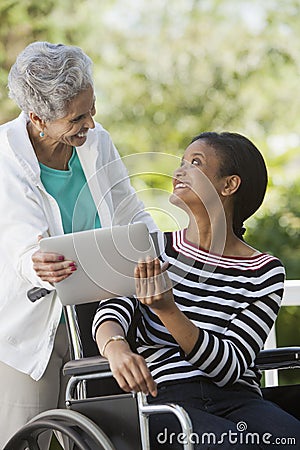 Disabled woman in a wheelchair with her mother Stock Photo