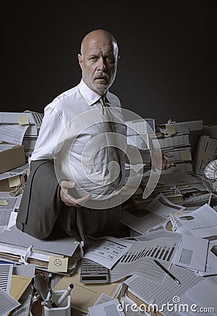 Disappointed business executive standing in his messy office Stock Photo