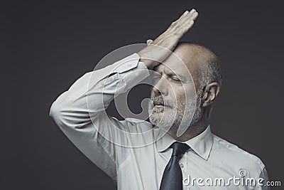 Disappointed businessman touching his forehead Stock Photo