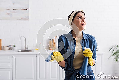 Disappointed housewife in rubber gloves holding Stock Photo