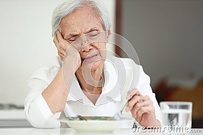 Disappointed old elderly people eating overnight food,she`s sick of food,tired of eating same food,lacking flavor,Asian senior Stock Photo