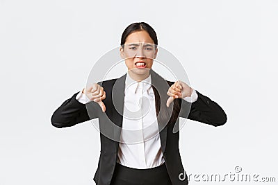 Disappointed skeptical and upset asian saleswoman complaining on bad product or service, showing thumbs-down and Stock Photo