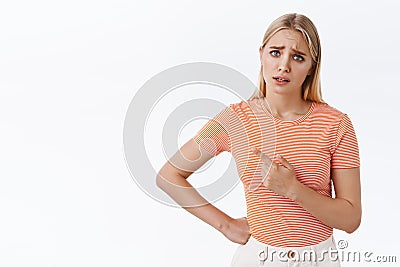 Disappointed and slightly upset gloomy cute blond girl, whining unwilling do daily duty as pointing left asking someone Stock Photo