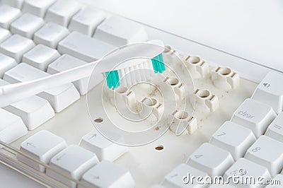 Disassemble and clean up a dirty white keyboard with a toothbrush. Stock Photo