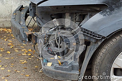 Disassembled broken front part of a black passenger car on the street Stock Photo