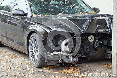 Disassembled broken front part of a black passenger car on the street Stock Photo