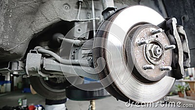 Disc brake of the vehicle for repair, in process of new tire replacement. Car brake repairing in garage. Stock Photo