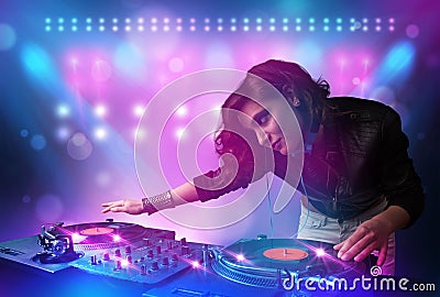 Disc jockey mixing music on turntables on stage with lights and Stock Photo