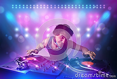 Disc jockey mixing music on turntables on stage with lights and Stock Photo