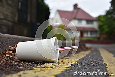 Discarded drinks container lying at the edge of an urban street Stock Photo