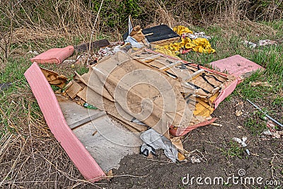 Discarded furniture in nature. Garbage Dumped in Beautiful Nature Stock Photo