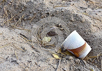 Discarded Paper coffee cup on ground. Disposable coffee cup on sand. The problem of environmental pollution. Pile of abandoned Stock Photo