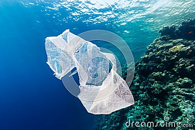 Discarded plastic bag drifting past a tropical coral reef Stock Photo