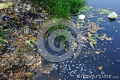 Discarded plastic debris polluting a waterway Stock Photo