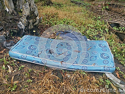 Discarded queen size mattress thrown in the farm Stock Photo