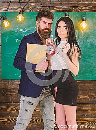 Discipline concept. Lady teacher and strict schoolmaster care about discipline and rules in school. Man with beard hold Stock Photo