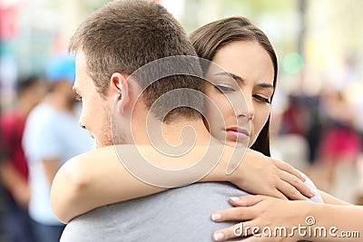 Discontent girlfriend hugging her partner Stock Photo