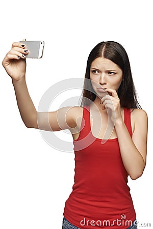 Discontent woman taking pictures of herself through cellphone Stock Photo