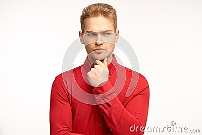 Discontent young businessman dressed a red shift, purses lower lip, looks stressfully, feels dejected by negative announcement Stock Photo