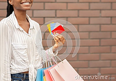 Discount and credit cards for purchases. Smiling female holding cards and packages in her hand Stock Photo