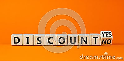 Discount symbol. Turned a wooden cube and changed words `discount no` to `discount yes`. Beautiful orange background. Business Stock Photo