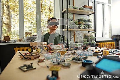 Discover What Is Possible. Child programming, testing robot vehicle, using console controller, working with wires and Stock Photo