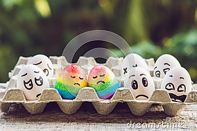 Discrimination gay concept. Two rainbow eggs in the form of a homosexual couple. And condemning people around Stock Photo