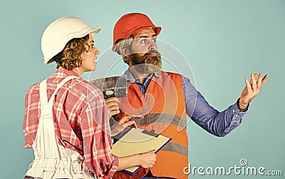 Discussing renovation with contractor. Price list. Couple look documents. Woman and man safety hard hat. Couple planning Stock Photo
