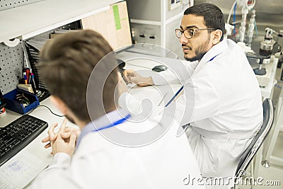 Discussing Working Process with Colleague Stock Photo