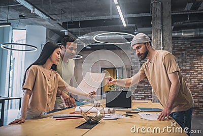 Girl and two guys discussing project Stock Photo