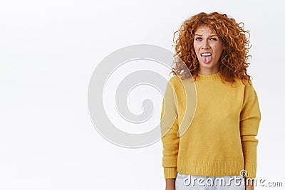 Disgusted, displeased silly redhead ginger girl, stick tongue and grimacing, cringe from awful smell, want puke from bad Stock Photo