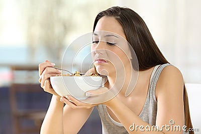 Disgusted woman eating cereals with bad taste Stock Photo