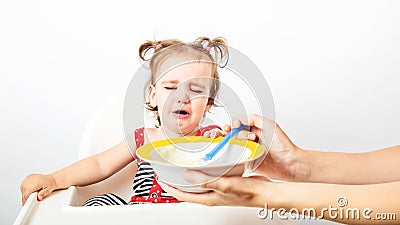 Disgusting kids nutrition. Cute baby crying, doesn`t want to eat meal Stock Photo