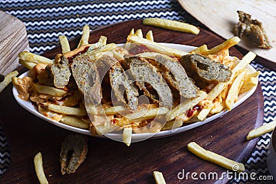 Dish of CHEESY SEEKH FRIES at cafe restaurant. American fast food dish, consisting of french fries covered in cheese Stock Photo