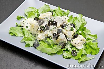 Dish of cod salad with black olives Stock Photo