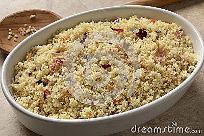 Dish with cooked couscous seasoned with a mix of dried flowers Stock Photo