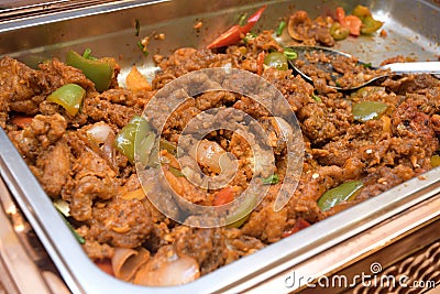 A dish of fried curry flavoured meat on a large open tray Stock Photo