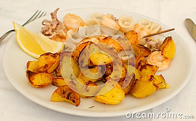 The dish of Fritto con spiedino e patate - potatoes and seafood fried, italian food Stock Photo