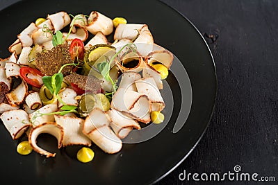 Dish of many pieces of lard with vegetables on black background Stock Photo