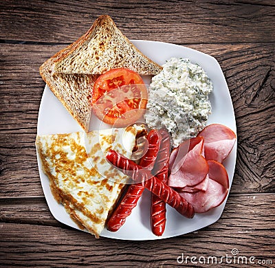 A dish with omelet, bacon and sausages. Stock Photo