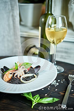 Dish of risotto with squid ink on grey plate jpg Stock Photo