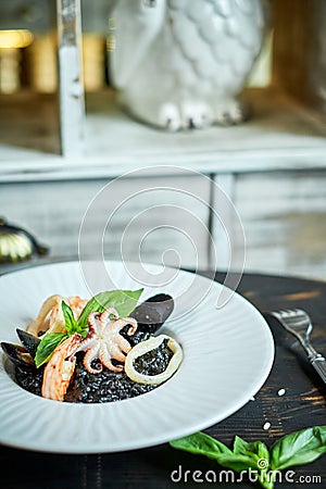 Dish of risotto with squid ink on grey plate jpg Stock Photo