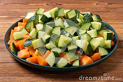 a dish with small pieces fresh cut cucumber and carrot Stock Photo