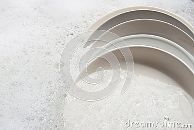 Dish washing, dishes soaking in kitchen sink Stock Photo