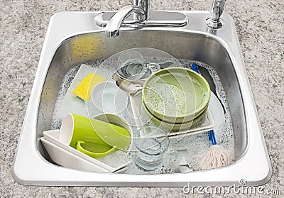 Dishes soaking in the kitchen sink Stock Photo