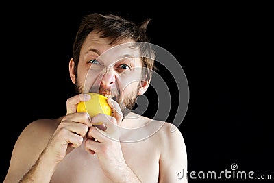 Dishevelled man eating a lemon Stock Photo