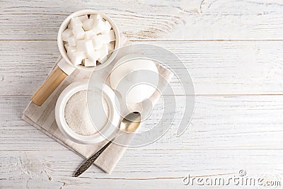 Dishware with sugar on white wooden table. Space for text Stock Photo