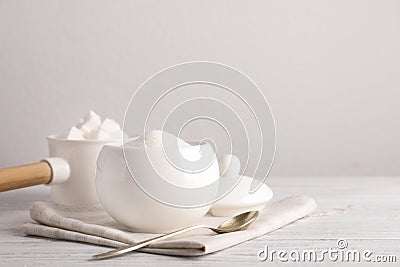 Dishware with sugar on white wooden table. Space for text Stock Photo